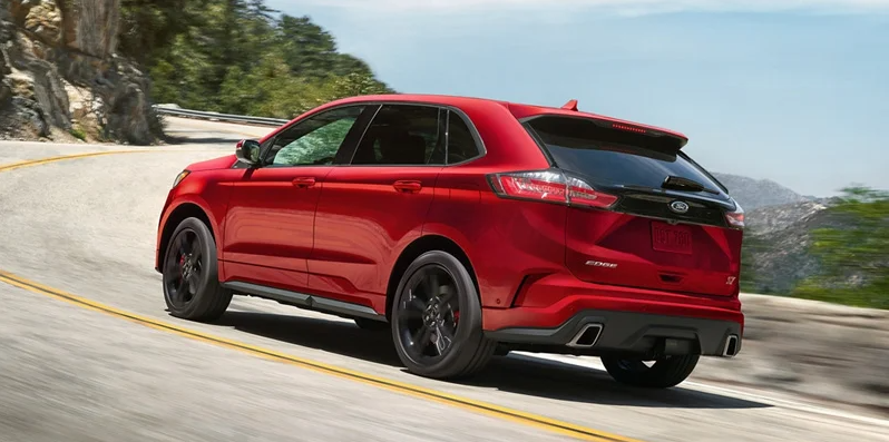 A photo of a red 2020 Ford Edge driving down the road.
